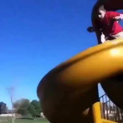 Kid goes down a slide on his bike