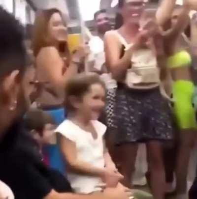 Little girl was crying in the train, these boys decided to make her smile and sang baby shark with her.