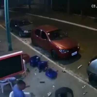 Car wheel violently disturbs peaceful man sitting outside a shop with friends. AXLE STILL ATTACHED