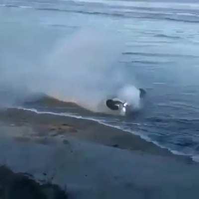 Riding a motorcycle through an approaching tide