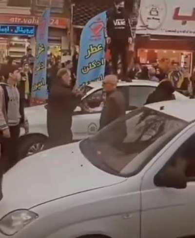 A girl standing on top of the Iran regime violent-loyal-police car without her hijab. The forces inside the cat don't dare get out and touch her.