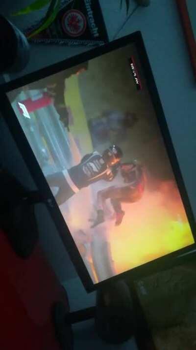 Grosjean being helped out of the crash scene