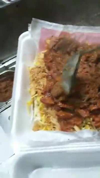 A Brazilian Hot Dog. Toppings include but are not limited to bacon, chilli, shredded chicken, olives, potato purée, creamy cheese, and mayonnaise.