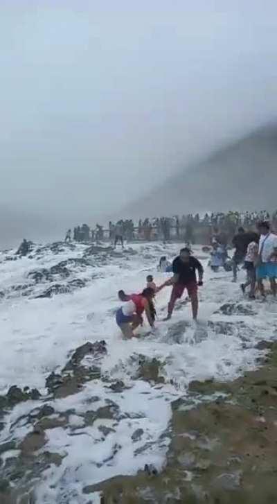 Women standing too close to a beach gets washed away