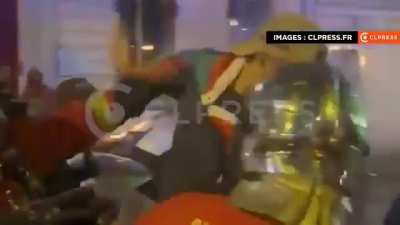 Rioters in Paris set fire to private property and then prevent firefighters from carrying out their job. One of them jumps on a firefighter's back.