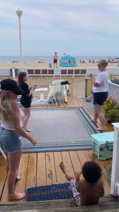 To hit his friend with a water balloon