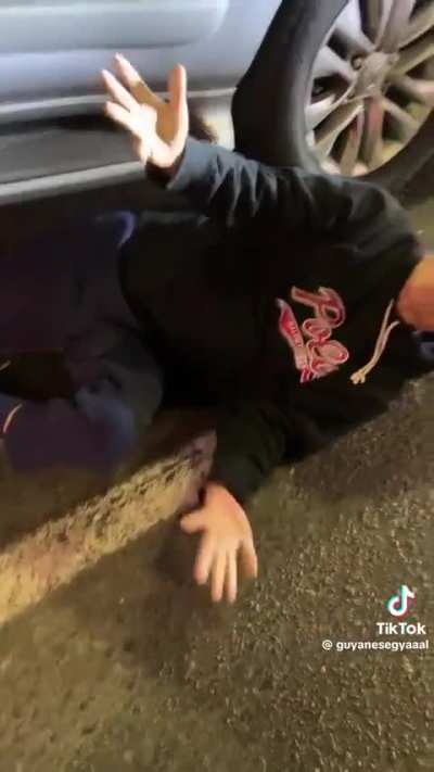 A guy goes under the car to stop the tow truck