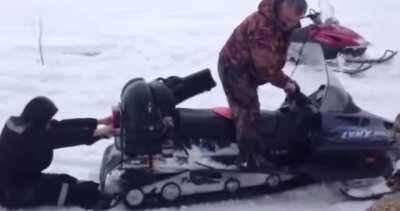 Standing behind a snowmobile