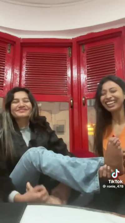 Two girls tickling each others feet to see who can last the longest