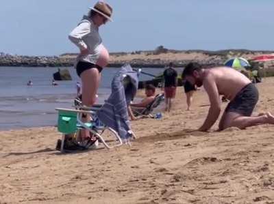 This guy dug a hole in the sand so his pregnant partner could lie in her stomach