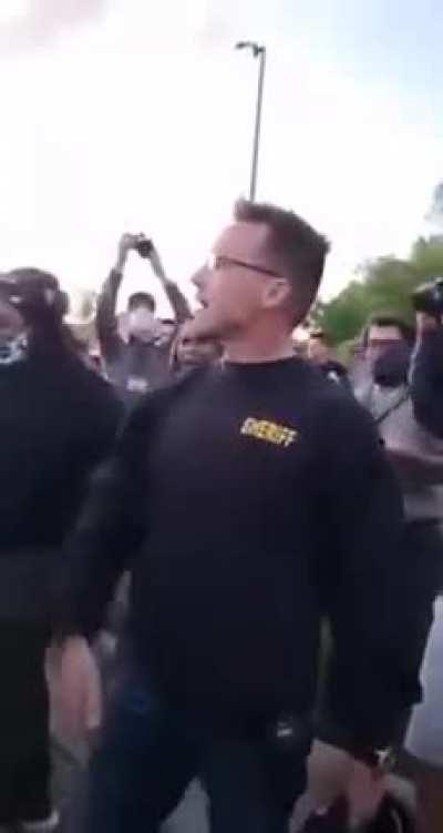 Meanwhile in Flint Michigan a police officer changes sides and joins the protesters