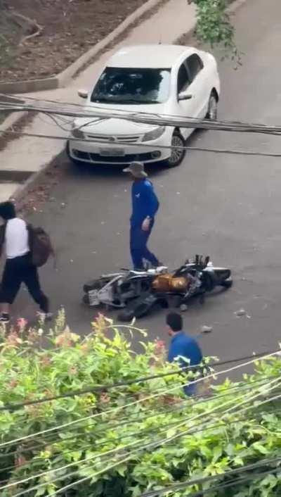 Aconteceu na Vila Indiana, em SP. Eram dois caras numa moto assaltando o rapaz de camiseta branca. O rapaz derrubou os caras da moto e segurou a moto para eles não fugirem. Um fugiu. Nisso o pessoal da prefeitura, que estava podando as árvores, veio ajuda