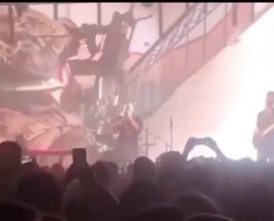 An Israeli Band plays scenes of the war in Gaza at the background as the crowd cheers on