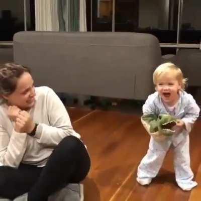 This child revealing his hand from under a crocodile puppet because the parent is scared
