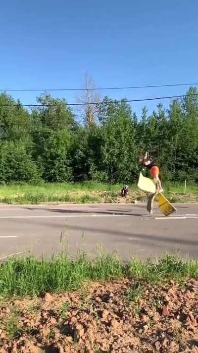 A guy backflips over running cars