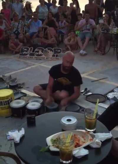 man makes electronic music with pans, buckets and other items