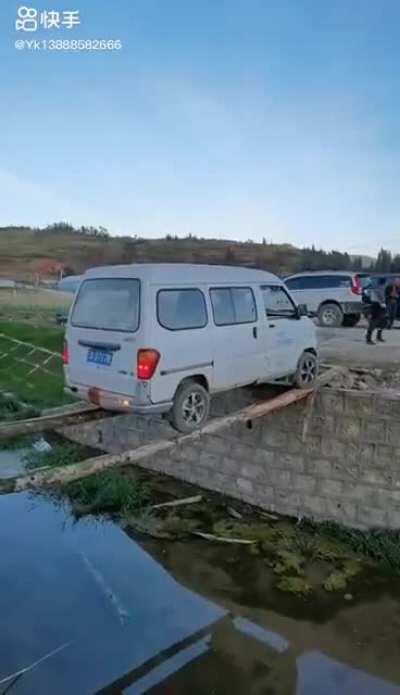 Chinese van attempting to drive over log bridge. Why backwards??