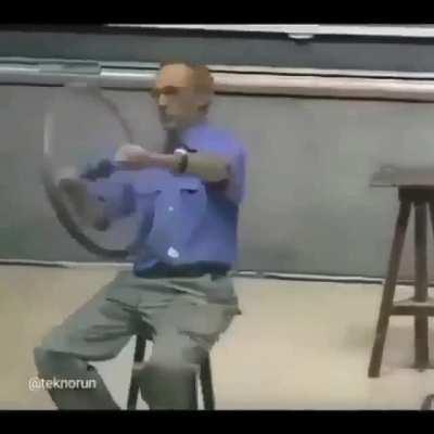 Physics professor demonstrating conservation of angular momentum