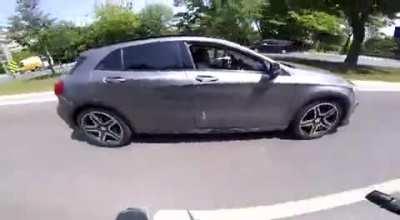 Motorcyclist gets hits by a car, follows her to make her pull over and gets stopped by other people who try to protect her.