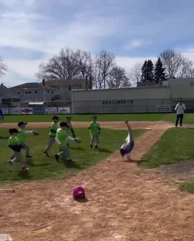 Almost the whole T-ball team runs in to tag the batter but she just cartwheels out of the way