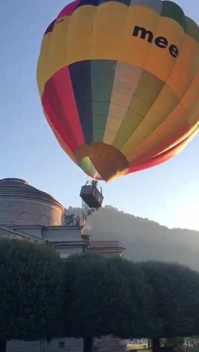 Lifting a hot-air-balloon during a mild wind