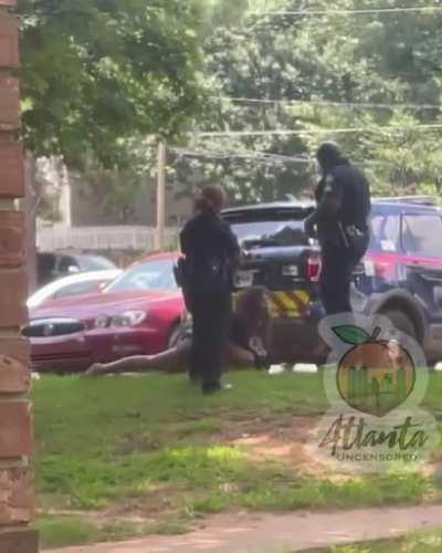 a cop was supsended after he was caught on camera kicking a woman while she's handcuffed and lying on the ground.