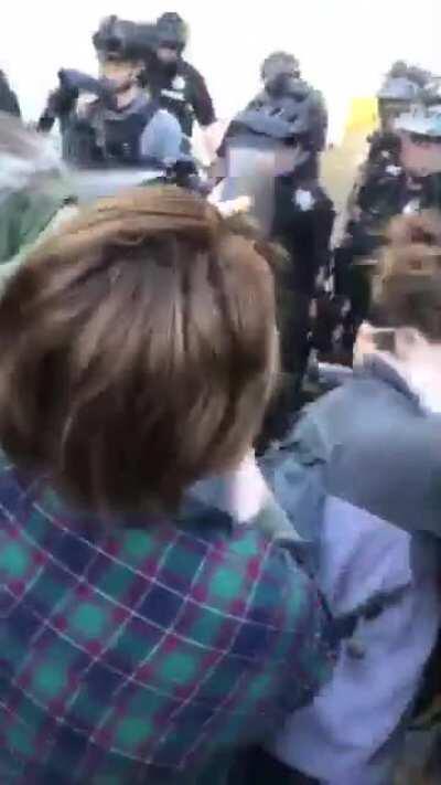 University Village, standing peacefully in front police at Safeway when an officer STRAIGHT MACES my classmate straight in the face