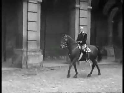 King Christian X on his daily ride though Copenhagen. Despite his old age, he took these unaccompanied rides during the first years of the German occupation. The other part shows him with his family. The little girl with the curly hair is his granddaughte