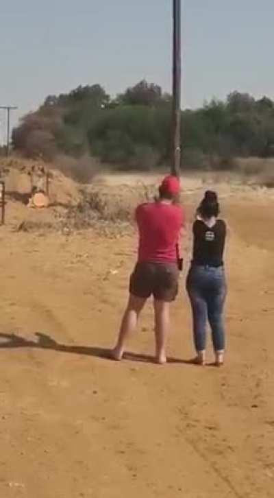 Guy shoots own leg while showing someone how to shoot.