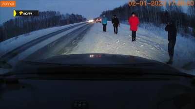 Car skids on the ice into group