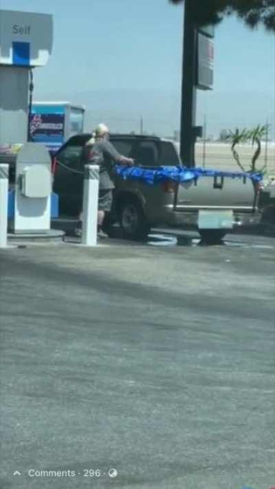 Topmind fills his truck bed tarp with gasoline as it leaks all over the ground