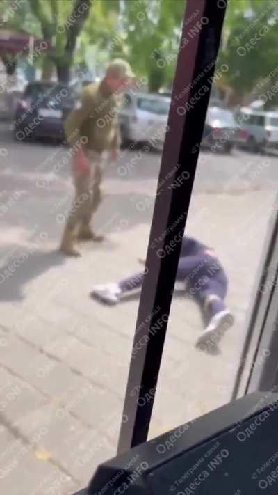RU POV: Ukrainian conscription officer is seen beating a man on the street to mobilise him.