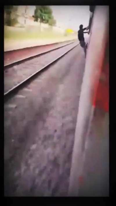 Indian guy leans very far out of very fast train and gets hit by a pole