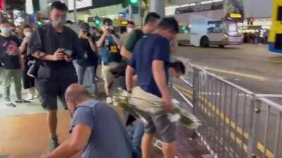 Plain clothes police kicking and trashing flowers for mourning the dead