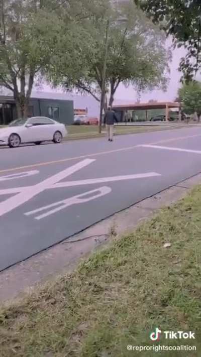 Planned parenthood escorts wave mugshots of Bible holding sex offender men that yell at women going into the clinic.