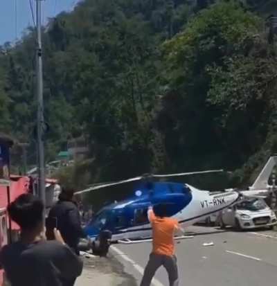 A helicopter bound for the Hindu temple town of Kedarnath makes an emergency landing on the highway.