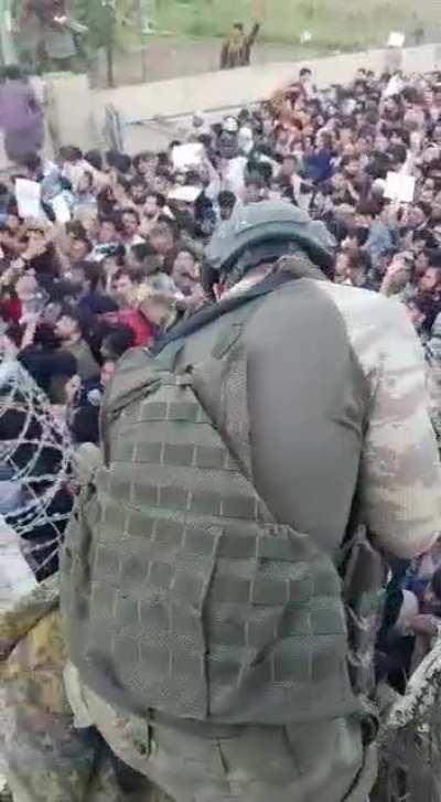 Azerbaijani peacekeepers lift Afghan children over wall at Kabul Airport