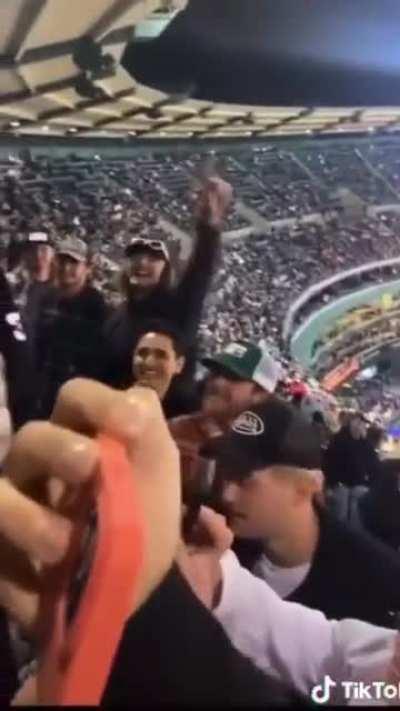 Woman gets mad at another woman for flashing her chest at a game where kids are also present, crowd throws beer on her.