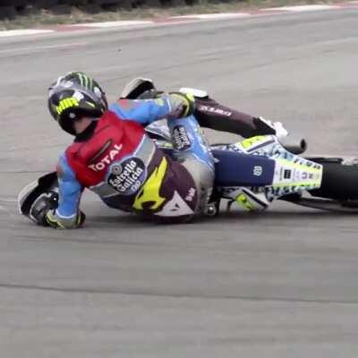 Moto2 rider on a supermoto@ gokart track, crazy lean angle sliding and dragging helmet.