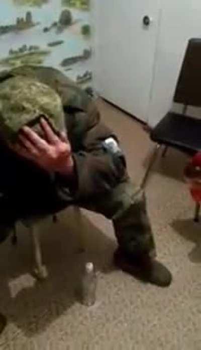 Russian soldier trying to break a vodka bottle over his head