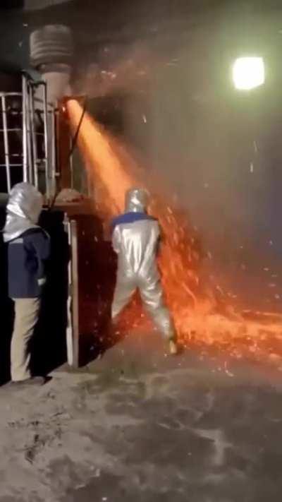 Man clears a blockage in steel works