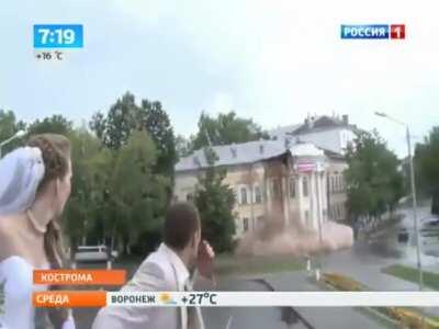 Walking up the steps to a chapel, a wedding couple gets photo bombed