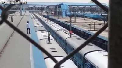 Man gets on top of train, lights a cigarette. Soon, sparks fly.