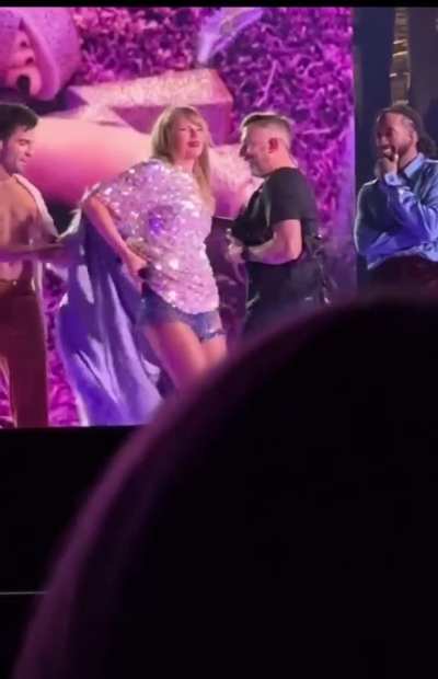 Taylor being the cutest while getting her mic pack fixed on stage (Indy N1)