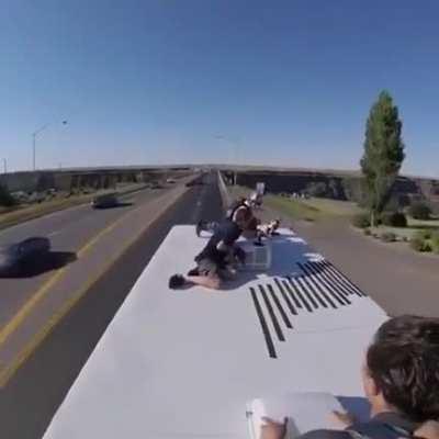 Parachuting off a truck driving over bridge