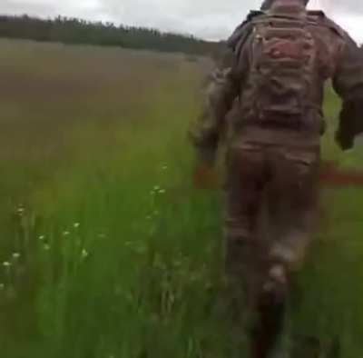 First-person view of Russian soldiers crossing a field to inspect a crashed but unexploded Ukrainian drone.