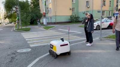Delivery robot met driverless car on intersection
