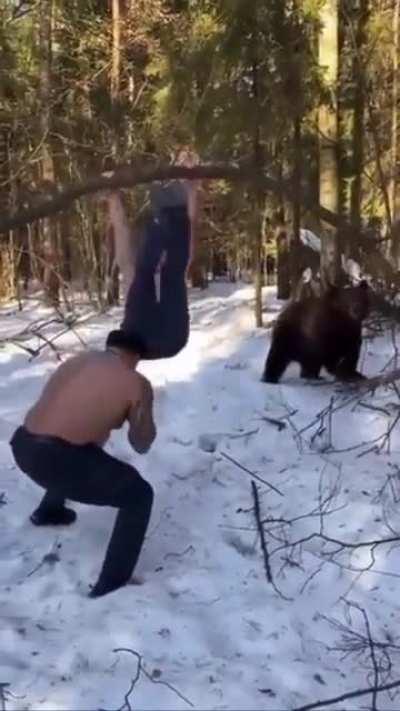 Slavic man trains in the woods, with the help of his instructor and his friend