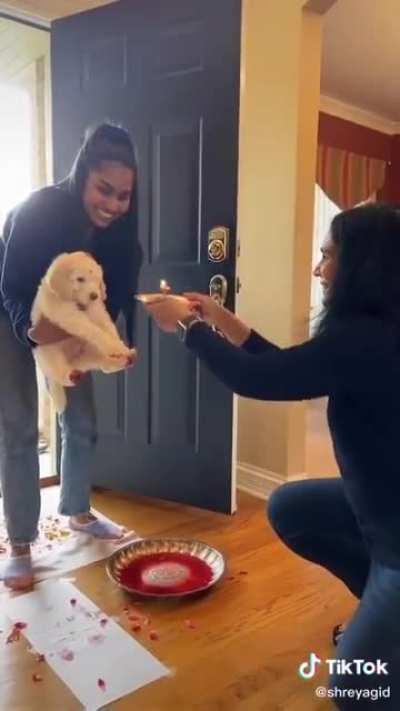 A Hindu family welcoming their new puppy with traditional ceremonies .