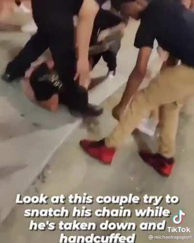 Couple tries to steal necklace off handcuffed man